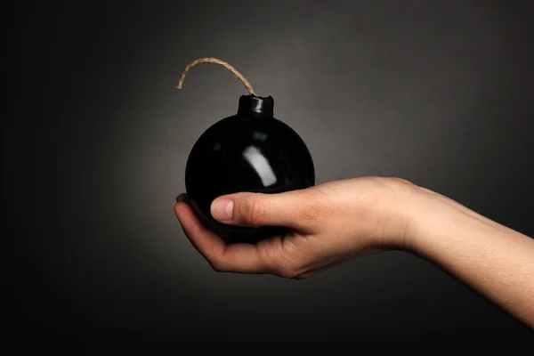 Бомба в стилі мультфільму в руці на чорному тлі — стокове фото