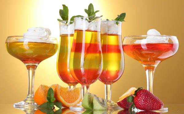 Gelatina di frutta in bicchieri e frutta su sfondo giallo — Foto Stock