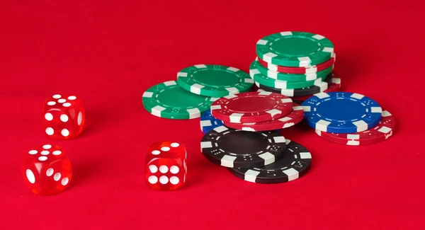 Μάρκες πόκερ με ζάρια σε ένα κόκκινο τραπέζι — Φωτογραφία Αρχείου