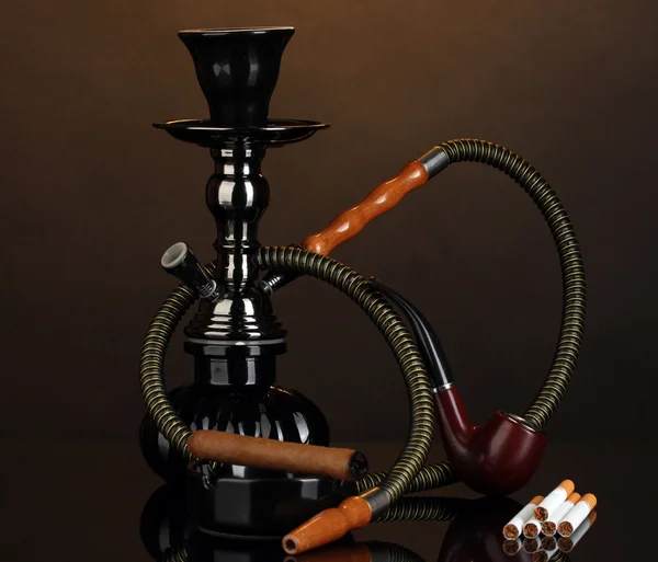 Інструменти для куріння - кальян, сигарета, цигарка та труба на коричневому фоні — стокове фото