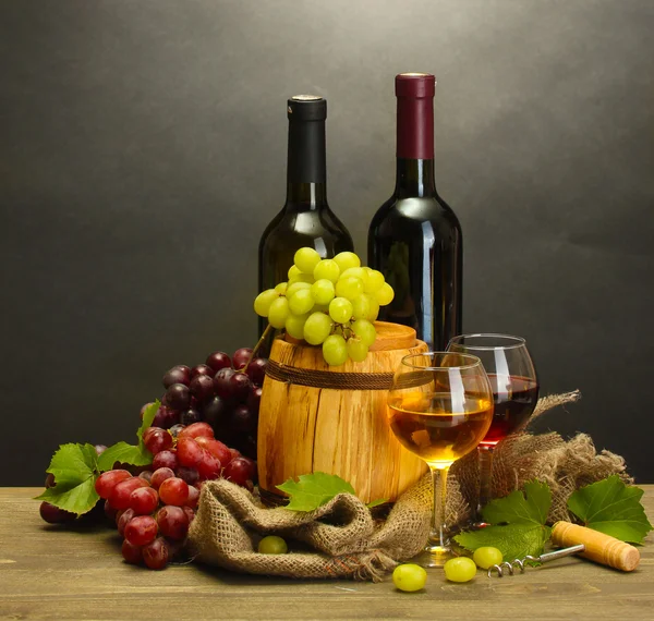 バレル、瓶、熟したブドウ灰色の背景上の木製のテーブルの上のワイングラス — ストック写真