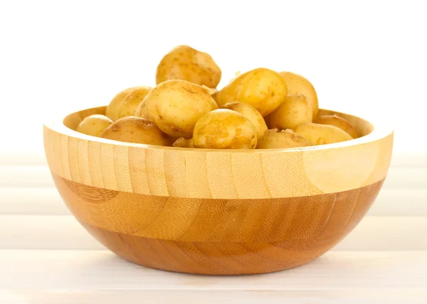 Jonge aardappelen in een houten kom op witte houten tafel close-up — Stockfoto