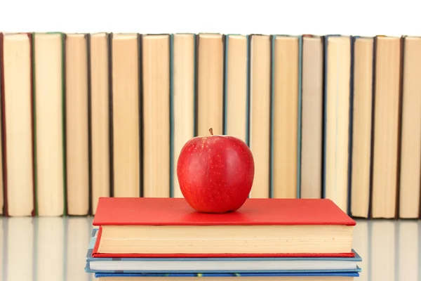 Куча книг с яблоком на белом фоне крупным планом — стоковое фото