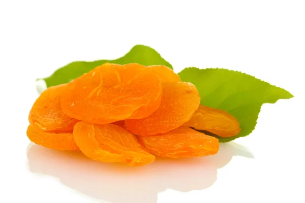 Läckra torkade aprikoser på gröna blad isolerad på vit — Stockfoto
