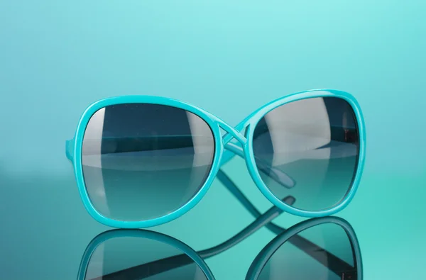 Parlak renkli arka plan üzerinde şık kadın mavi güneş gözlüğü — Stok fotoğraf