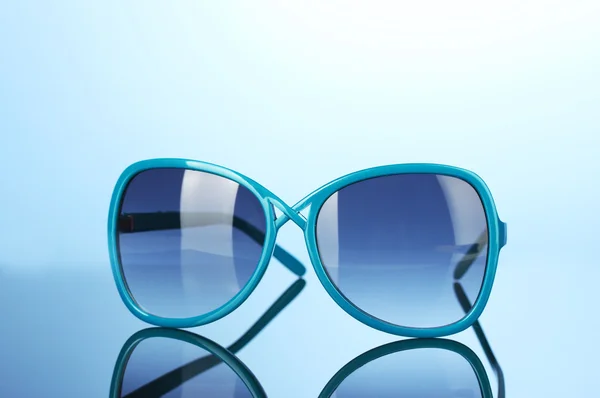 时尚女装蓝色太阳镜上明亮的彩色背景 — 图库照片
