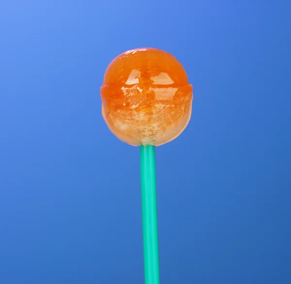 Sweet and tasty lollipop on bright blue background close-up — Stock Photo, Image