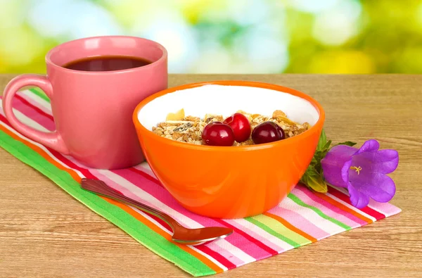Sabroso cereal con cerezas para el desayuno en mesa de madera sobre fondo verde —  Fotos de Stock