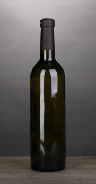 gri zemin üzerine ahşap masa üzerinde büyük şarap şişesi