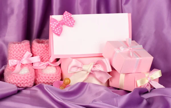 ピンクの赤ちゃんブーツ、pacifierd、はがきやシルクの背景上のギフト — ストック写真