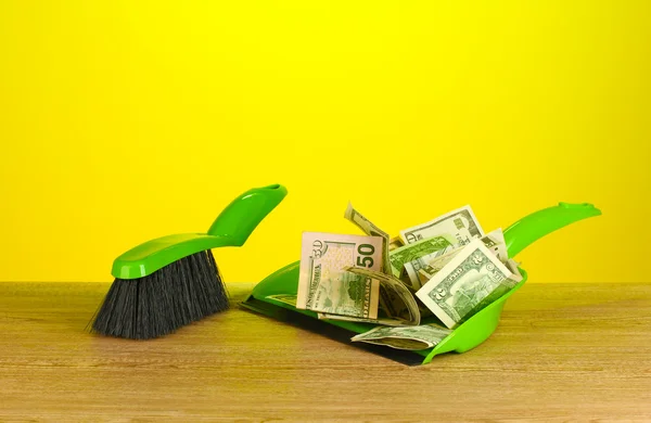Ogarnia pieniądze w łopatę na kolorowe tło zbliżenie — Zdjęcie stockowe