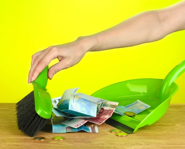 Sweeps money in the shovel on colorful background close-up — Stock Photo, Image