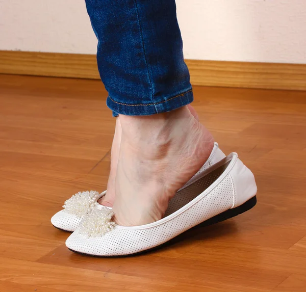 Nohy v džínách a ploché baletky na dřevěné pozadí — Stock fotografie