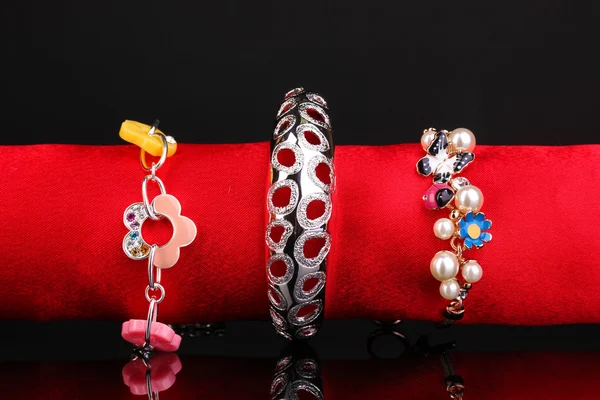 Three beautiful bracelets on the red cloth on black background — Stock Photo, Image