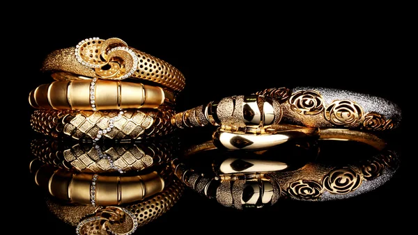 Belas pulseiras douradas isoladas no fundo preto — Fotografia de Stock