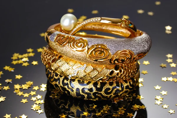 Beautiful golden bracelets on grey background — Stock Photo, Image