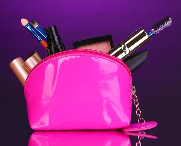 Make up bag with cosmetics and brushes on violet background — Zdjęcie stockowe