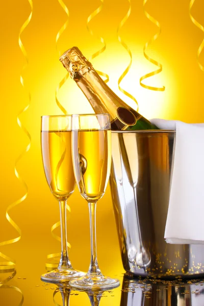 Kova buz ve şampanya, Sarı zemin üzerine bir bardak şampanya şişesi — Stok fotoğraf