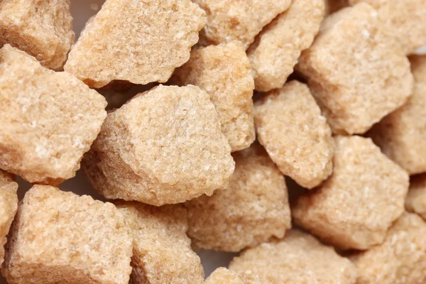 Hnědý třtinový cukr kostky pozadí detail — Stock fotografie