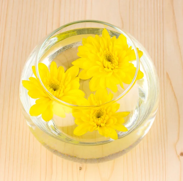 Vaso com flores amarelas em fundo de madeira — Fotografia de Stock