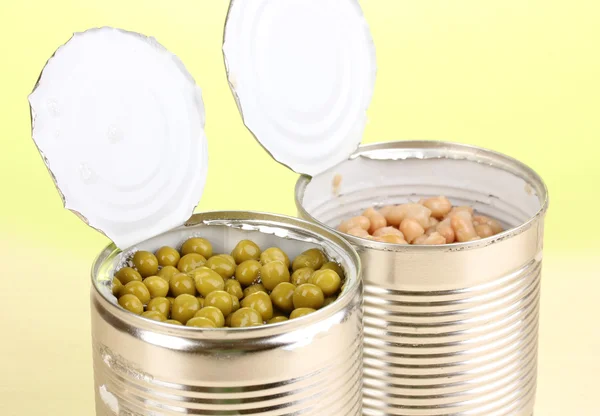 エンドウ豆および豆緑色の背景で木製のテーブルの上の缶を開く — ストック写真