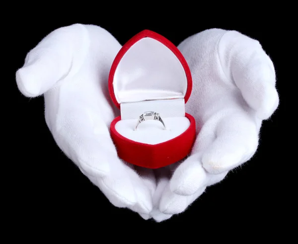 Las manos del hombre sosteniendo el anillo en caja sobre fondo negro — Foto de Stock