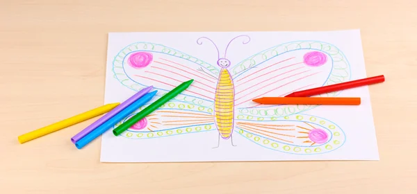 Children's drawing of butterfly and pencils on wooden background — Stock Photo, Image