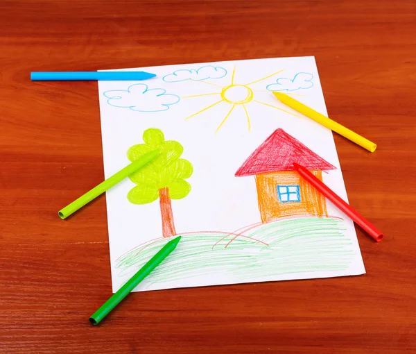 Children's drawing of house and pencils on wooden background — Stock Photo, Image