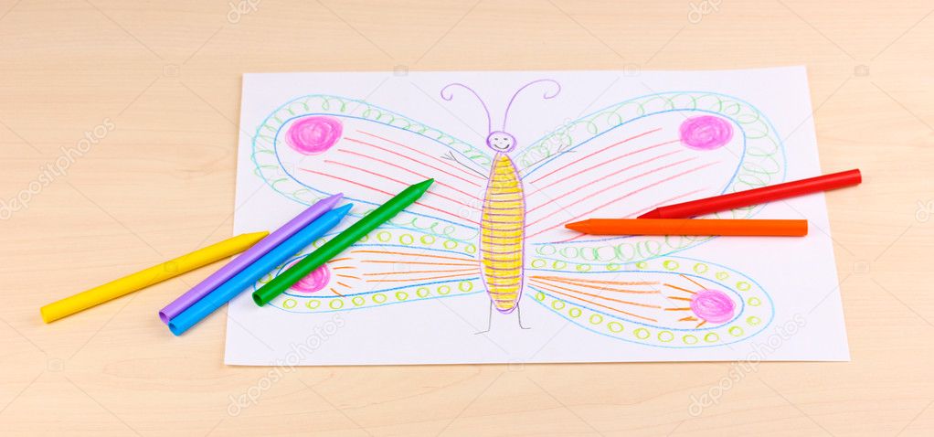 Kids drawing of family and colored pencils on wooden table Stock