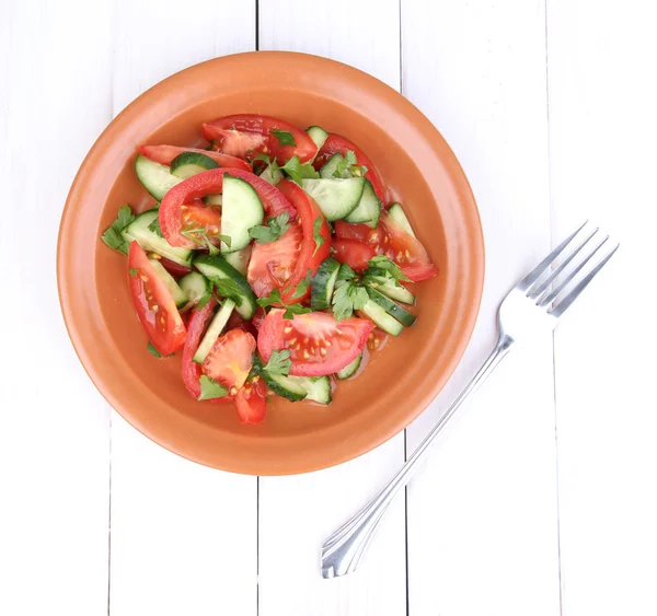 Ensalada fresca con tomates y pepinos sobre fondo de madera blanca — Foto de Stock