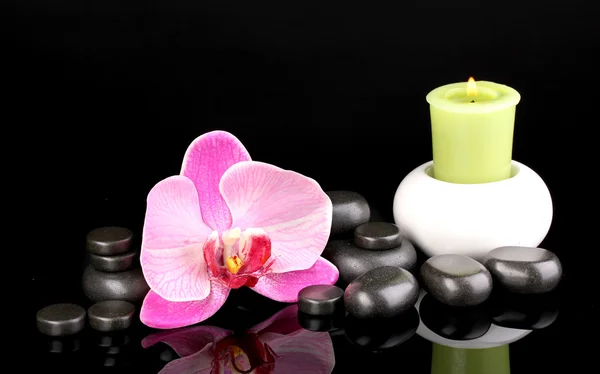 Pedras de spa com flor de orquídea e vela isoladas em preto — Fotografia de Stock