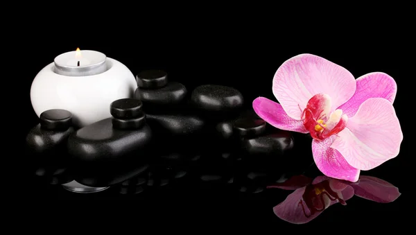 Spa stenen met orchideebloem en kaars geïsoleerd op zwart — Stockfoto