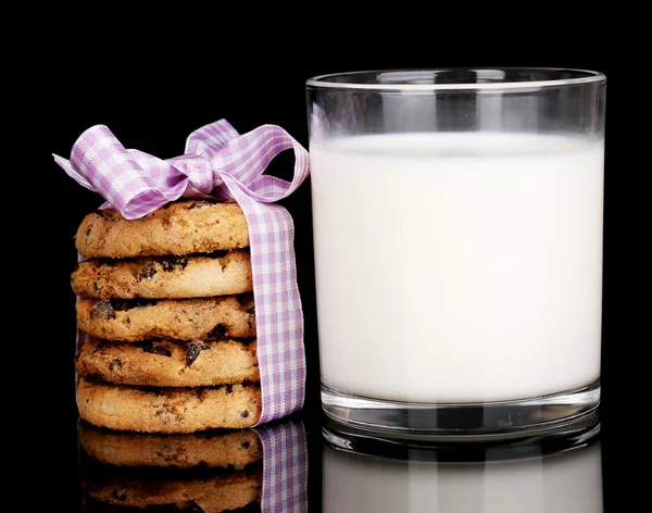 Bicchiere di latte e biscotti isolati su nero — Foto Stock