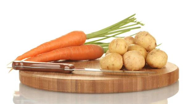 Jeunes pommes de terre et carottes sur une planche à découper avec couteau isolé sur blanc — Photo