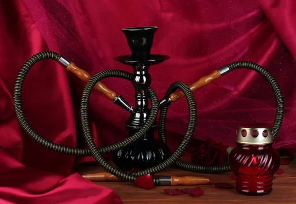 Hookah on a wooden table on a background of red curtain close-up — Stock Photo, Image