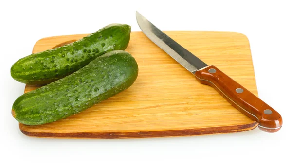 Fresh cucumbers and knife on cutting board isolated on white — Stock Photo, Image