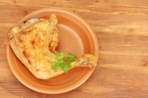 Ψητό πόδι κοτόπουλου με μαϊντανό στο πιάτο σε κοντινό πλάνο ξύλινο, παρασκήνιο — Φωτογραφία Αρχείου