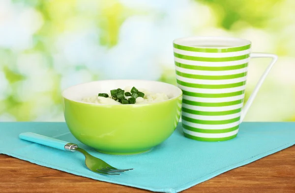 Kase ve ahşap arka plan üzerinde renkli peçete üzerinde Süt bardağı patates püresi — Stok fotoğraf