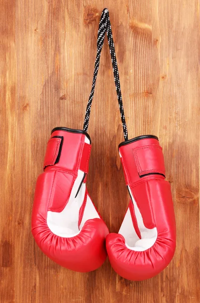 Czerwone Rękawice bokserskie wiszące na drewniane tła — Zdjęcie stockowe