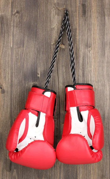 Rode bokshandschoenen opknoping op houten achtergrond — Stockfoto