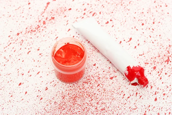 与红水粉和管与红色的喷漆特写背景上的红色水彩 jar — 图库照片