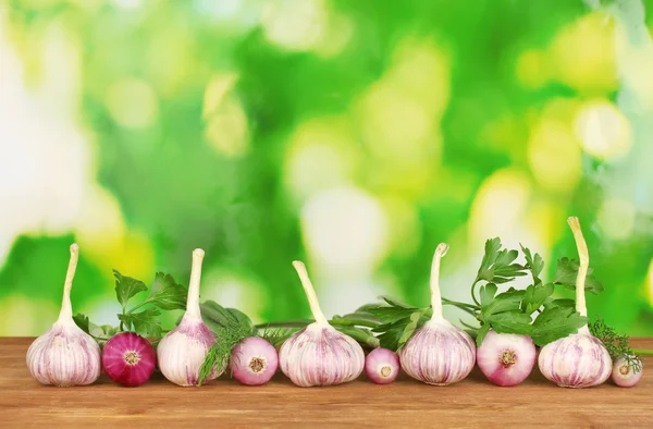 Junger Knoblauch und Zwiebeln auf Holztisch auf hellgrünem Hintergrund Nahaufnahme — Stockfoto