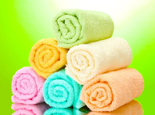 Colorful towels on green background — Stock Photo, Image