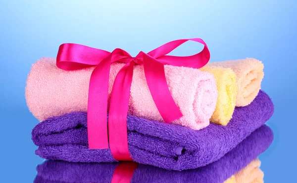 Barevné ručníky s mašlí na modrém pozadí — Stock fotografie