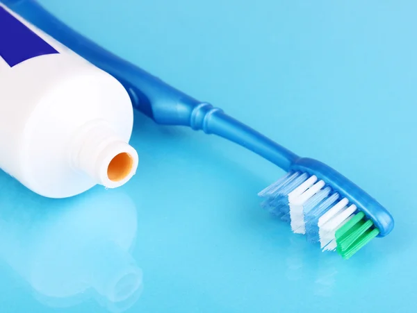 Cepillo de dientes y pasta sobre fondo azul —  Fotos de Stock