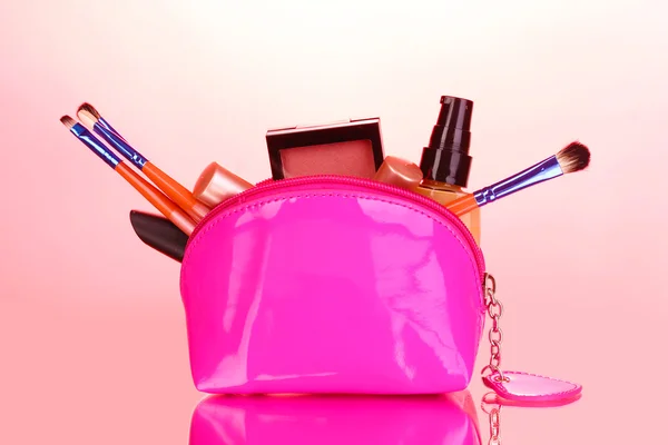 Sac de maquillage avec cosmétiques et brosses sur fond rose — Photo