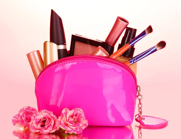 Макіяж сумка з косметикою та пензлями на рожевому фоні — стокове фото