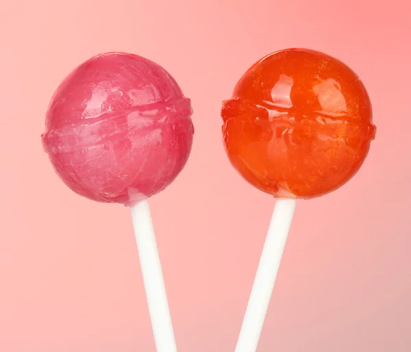 Bright and delicious lollipops on pink background close-up — Stock Photo, Image