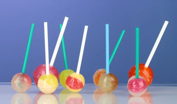 Bright and delicious lollipops on dark blue background close-up — Stock Photo, Image