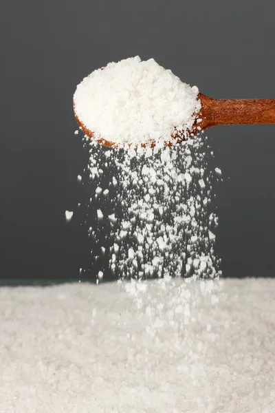 Wooden spoon with sea salt on a gray background close-up — Stock Photo, Image